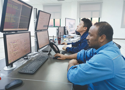 　　在米桑油田的中控室，中伊两国值班人员正通过电脑屏幕控制油田设备。 本报记者 曲翔宇摄
