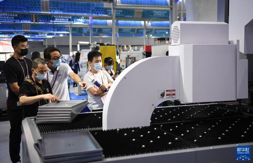 　10月15日，在第130屆廣交會上，機械設備參展商（左三）向觀眾介紹產品性能。新華社記者 鄧華 攝