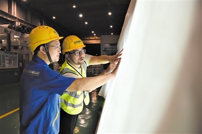 　岳阳林纸股份有限公司出口拓展部部长王子刚（右一）在车间查看产品。记者 白田田 摄