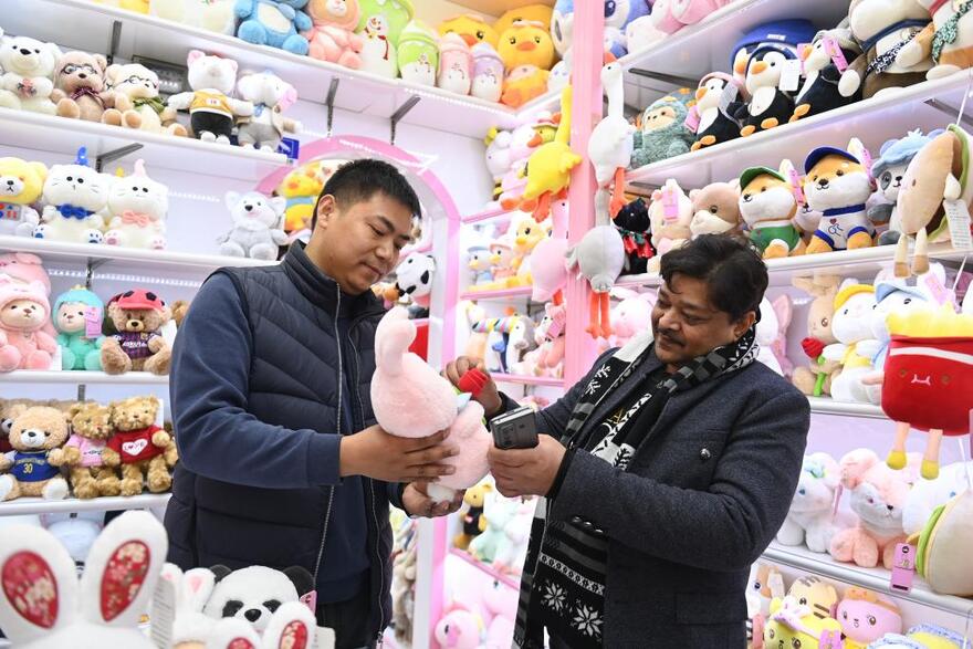 　2月2日，來自印度的客商拉賈（右）在義烏國際商貿城的一家玩具店鋪內選購。新華社記者黃宗治 攝
