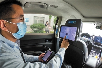 在北京中关村亦庄园，乘客体验“主驾无人、副驾驶配备安全员”的无人驾驶车。 　　彭子洋摄（新华社发）