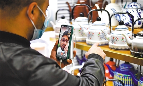 1月14日，也门客商在浙江义乌国际商贸城选购茶壶，同时通过视频向沙特客户介绍价格和库存。 新华社记者 黄宗治摄