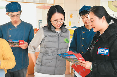 　　浙江省湖州市吴兴区工作人员（右一）向某企业员工发放旅游消费券。 　　新华社记者 黄宗治摄