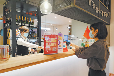 在海南海口市的一家咖啡店，顾客使用银行信用卡积分兑换的优惠券进行结算。 　　李 甜摄